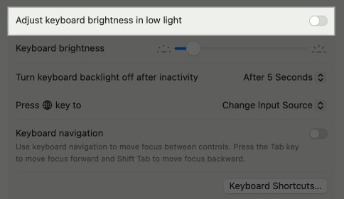 Adjust Keyboard Brightness in Low Light option in MacBook System Settings.