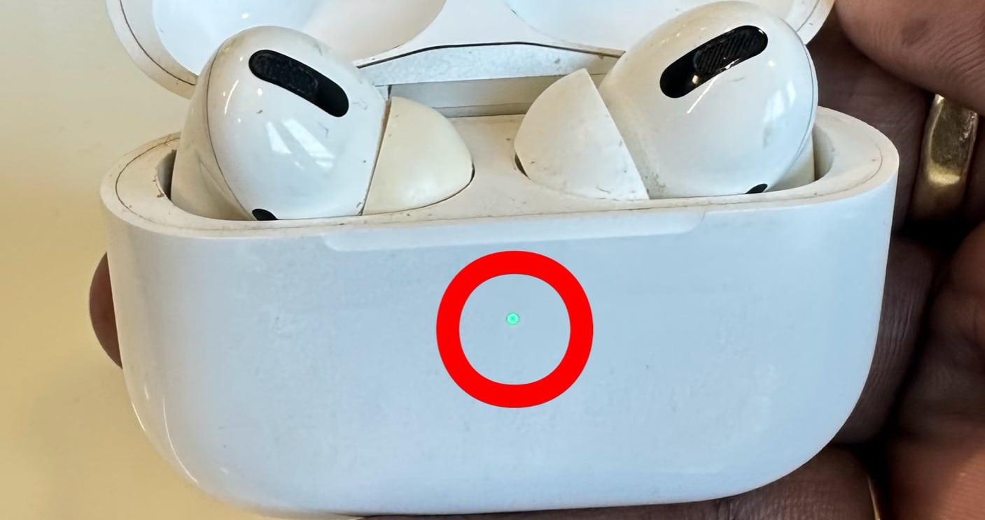 Green LED indicator on AirPods indicating battery fully charged.