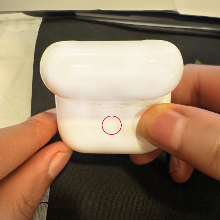 Setup button on the back of an airpods' charging case.