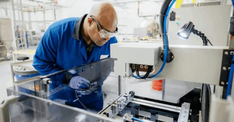 Worker inspecting manufacturing equipment in an Apple supply chain facility