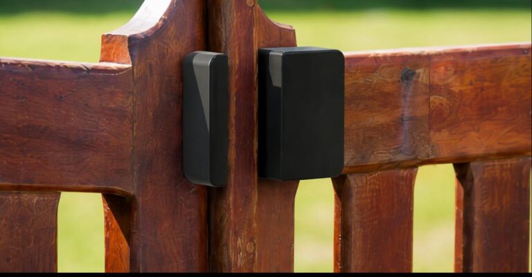 Close-up of Abode Outdoor Contact Sensor mounted on a wooden gate