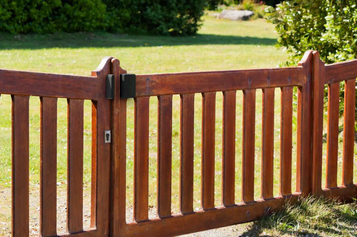 Abode Outdoor Contact Sensor mounted on a wooden garden gate