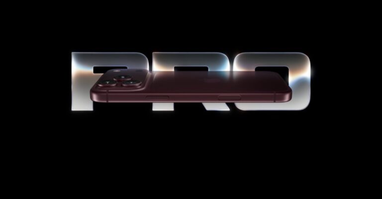 Burgundy iPhone Pro resting across large 'PRO' lettering on a black background.