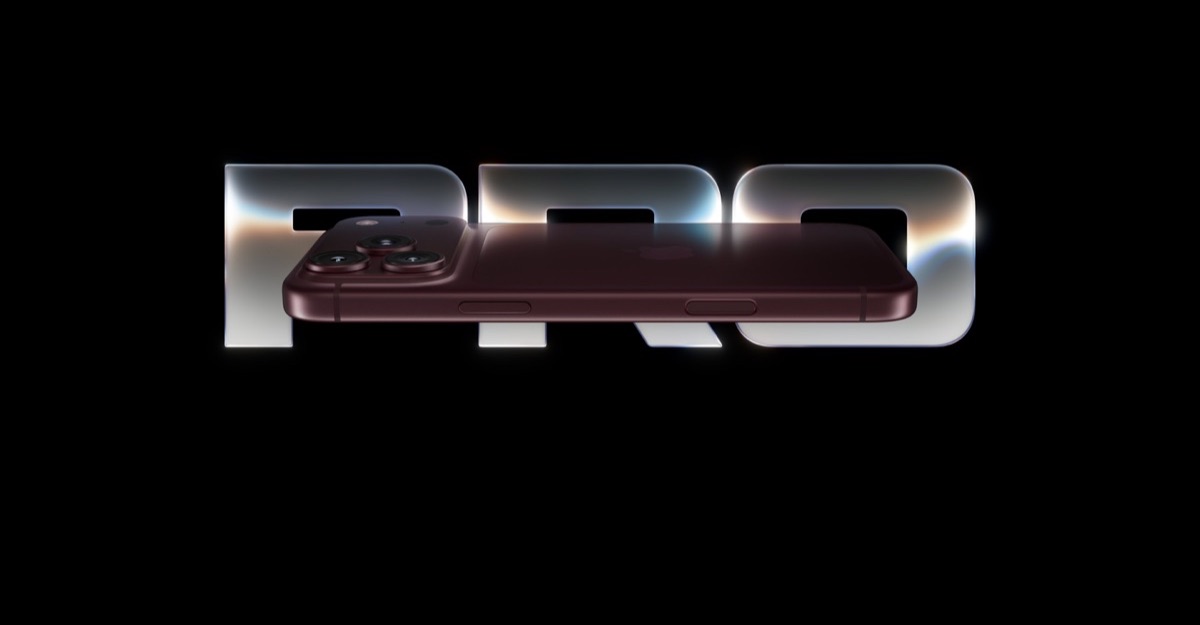 Burgundy iPhone Pro resting across large 'PRO' lettering on a black background.