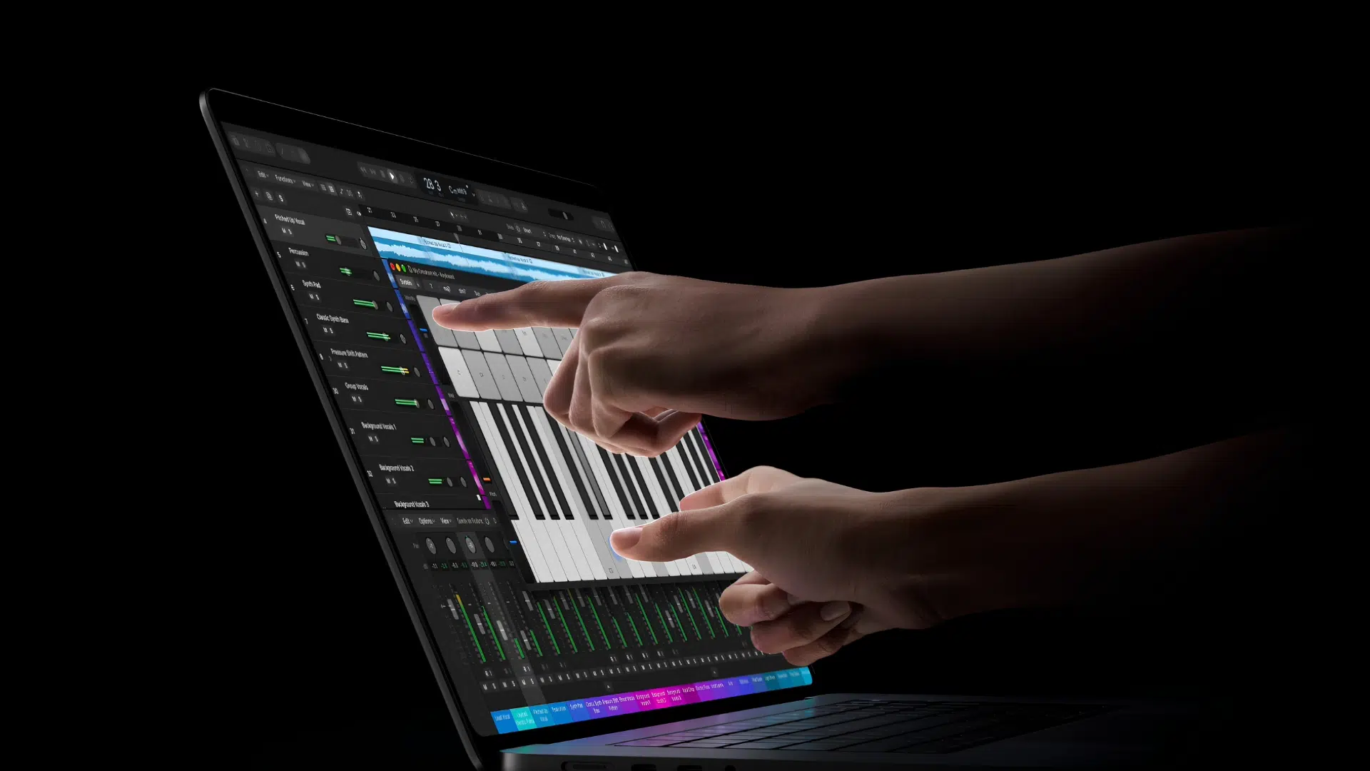 Hands type on a laptop displaying a digital audio workstation with multiple tracks and a piano roll in a dark studio setting
